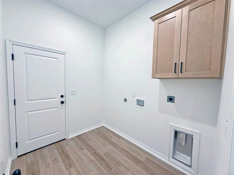 Washroom featuring light wood-type flooring, washer hookup, cabinet space, and electric dryer hookup