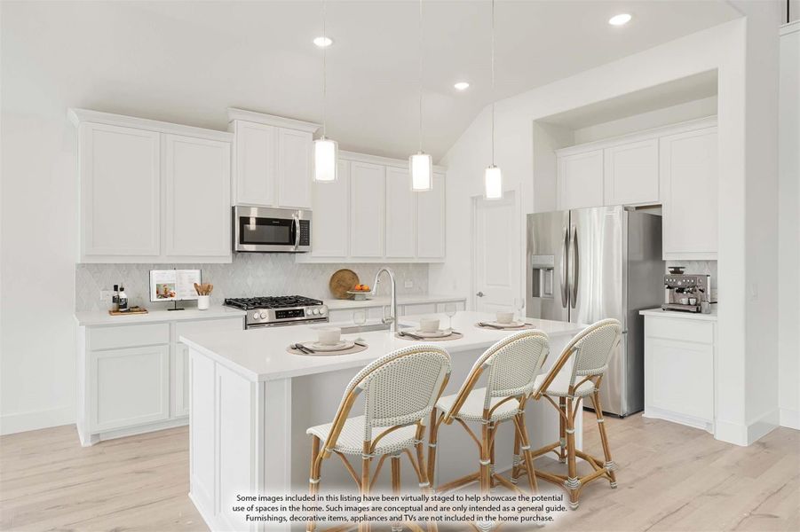White kitchen with center island, three bar stools, pendant lights, and stainless steel appliances