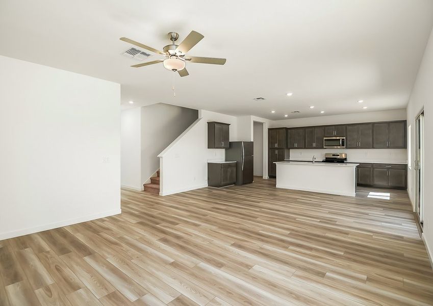 Wide family room view with kitchen and staircase in Wellton floor plan