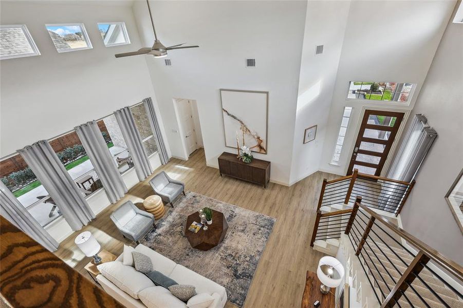 Two-story living area featuring a vaulted ceiling and a contemporary ceiling fan