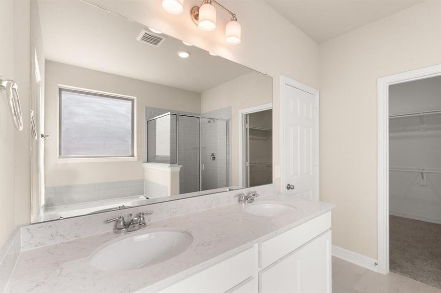 The en-suite bathroom offers a spa-like atmosphere with its elegant design, high end finishes, and tasteful lighting, creating a retreat within your own home.