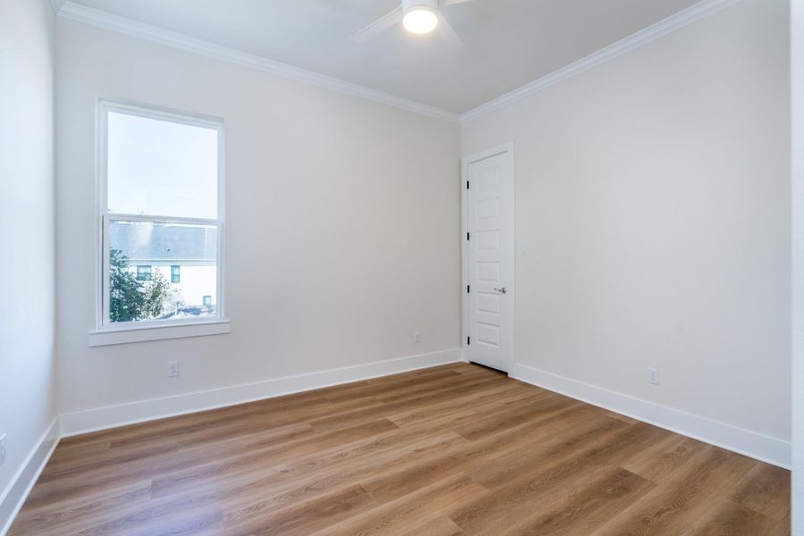 The fourth bedroom features vinyl flooring and a ceiling fan. The fourth bedroom features vinyl flooring and a ceiling fan.