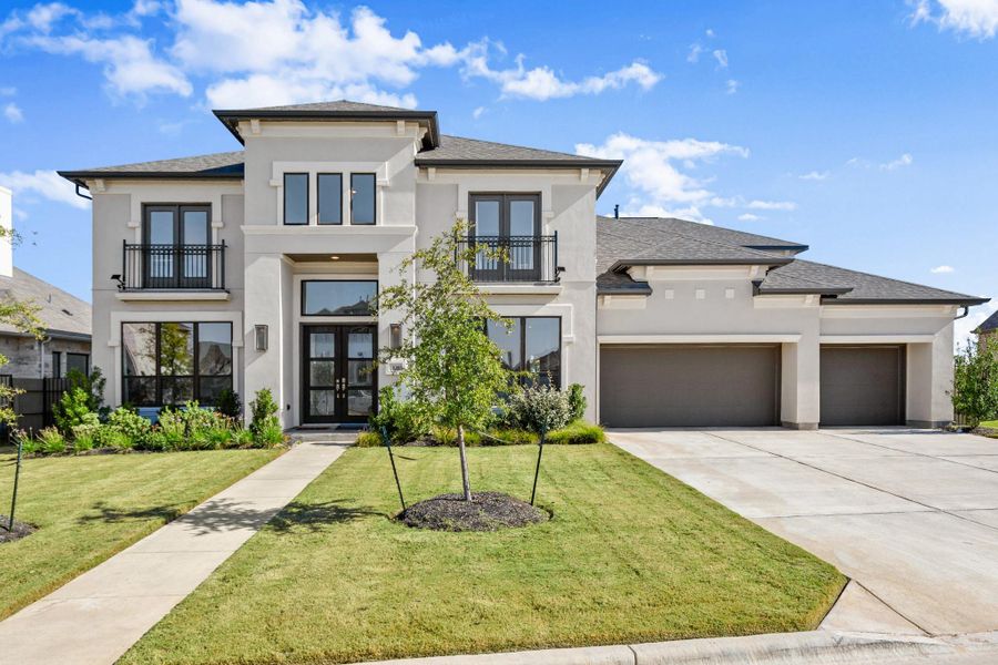 View of front of property featuring french doors, a balcony, stucco siding, a garage, and a front lawn View of front of property featuring french doors, a balcony, stucco siding, a garage, and a front lawn