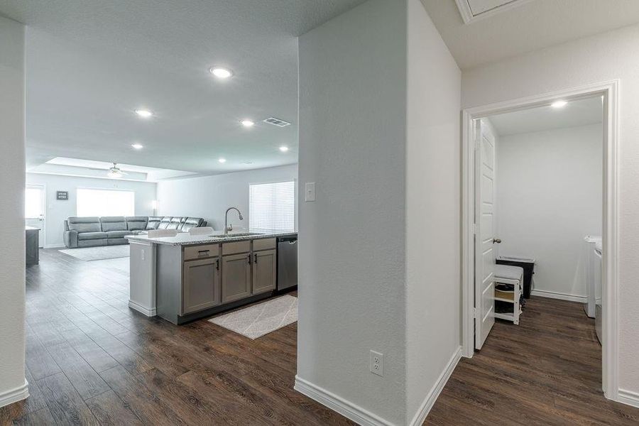 Views from foyer into open kitchen and den with laundry room to right Views from foyer into open kitchen and den with laundry room to right