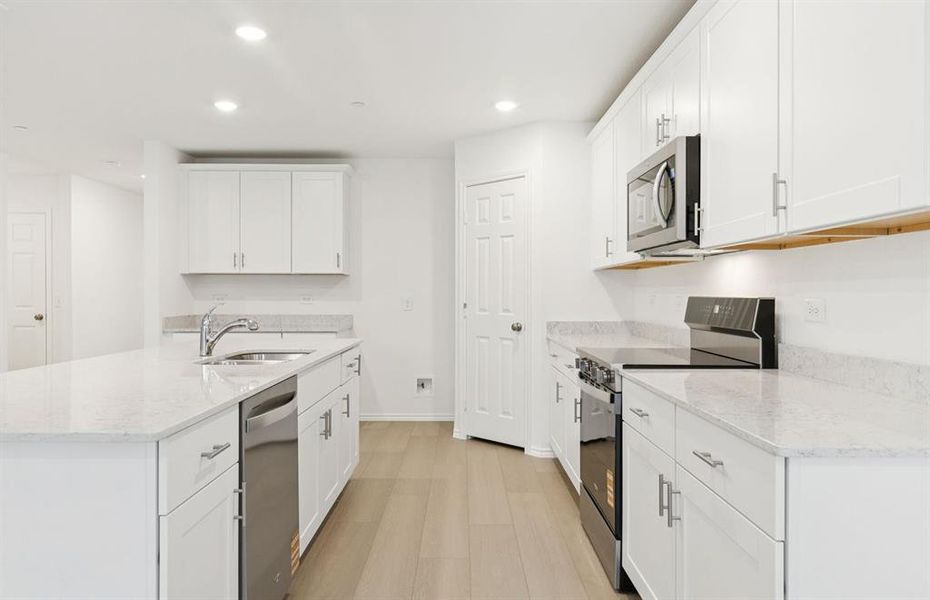 Large island overlooking gathering room and dining areas