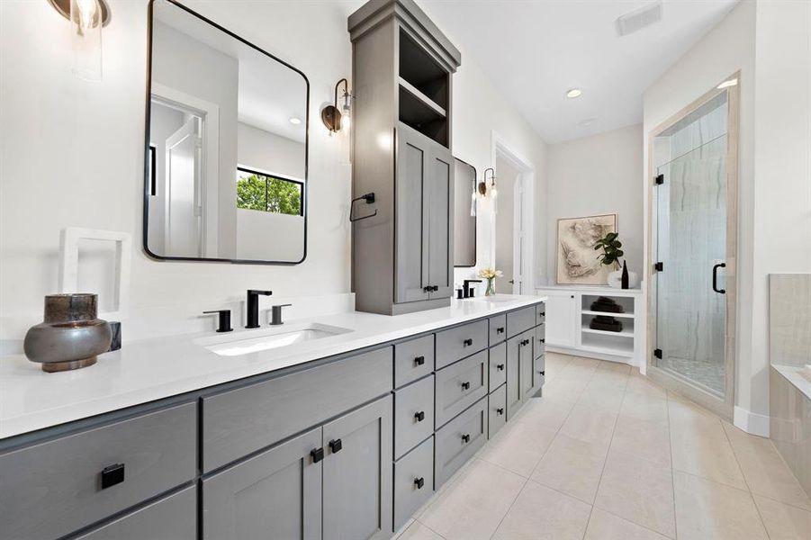 Thoughtful finishes adorn the serene primary bath with double sinks, sleek fixtures, and space for a future beverage fridge.