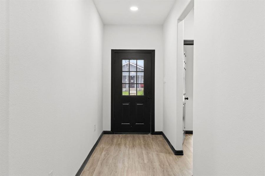 Doorway with light hardwood / wood-style flooring