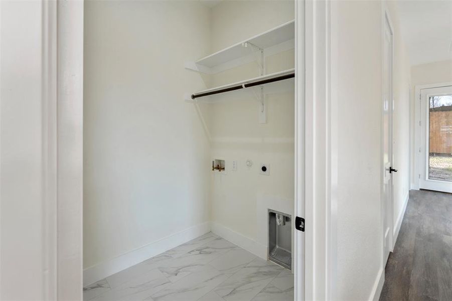 Washroom featuring hookup for a washing machine, gas dryer hookup, light marble finish floors, and electric dryer hookup Washroom featuring hookup for a washing machine, gas dryer hookup, light marble finish floors, and electric dryer hookup