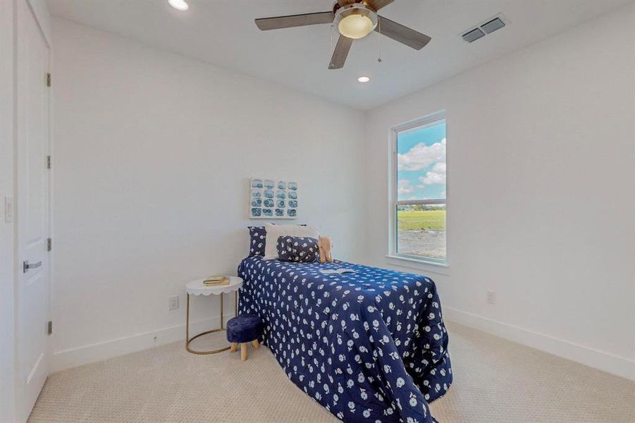 Carpeted bedroom with ceiling fan