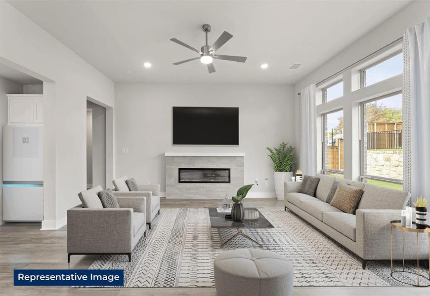 Living area with a ceiling fan, light wood-style floors, a premium fireplace, and recessed lighting