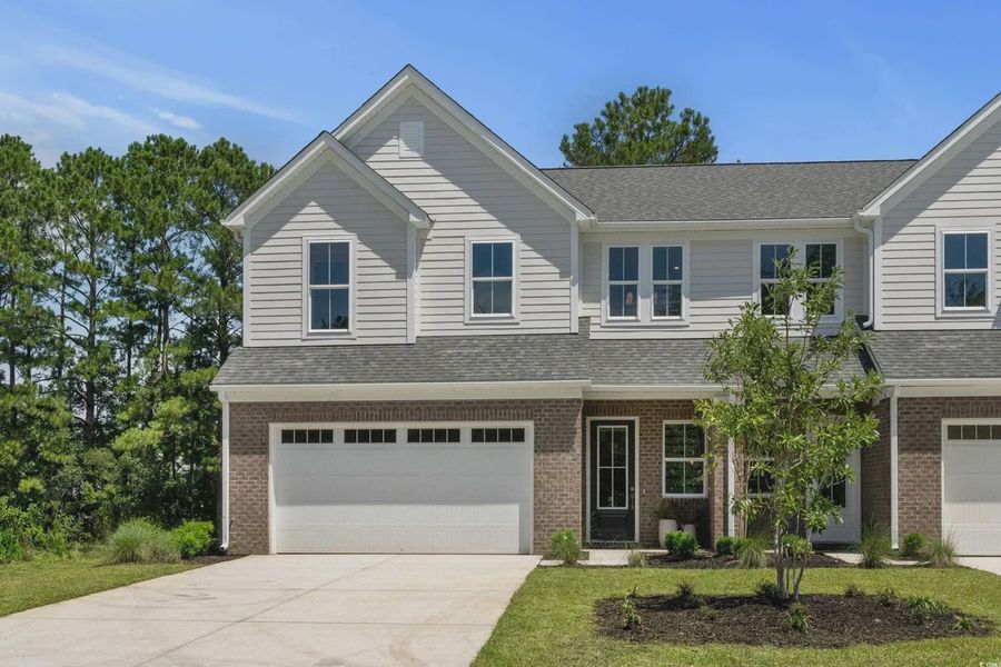 Front exterior of a new home in Long Bay Golf Club, Longs, SC, highlighting curb appeal (Image 1).