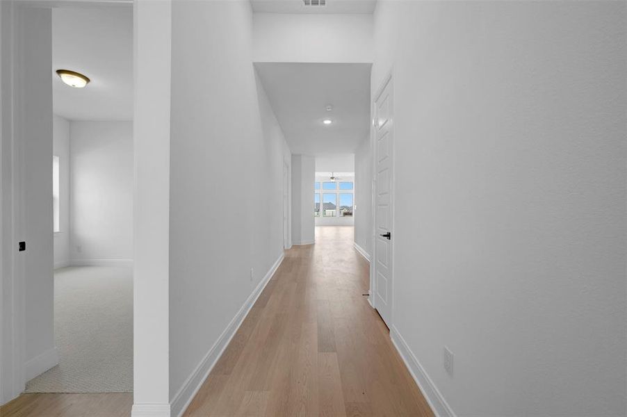Corridor with light wood-style floors and recessed lighting