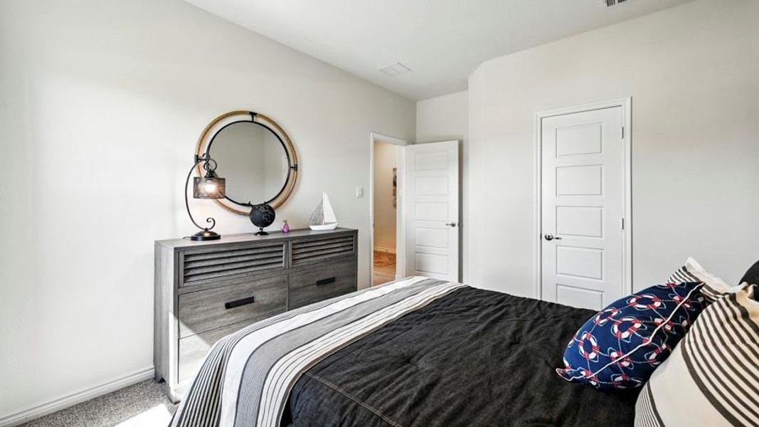 Bedroom featuring light colored walls, carpeting, and a modern style dresser