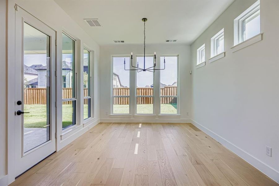 Unfurnished dining area featuring a chandelier and light wood finished floors