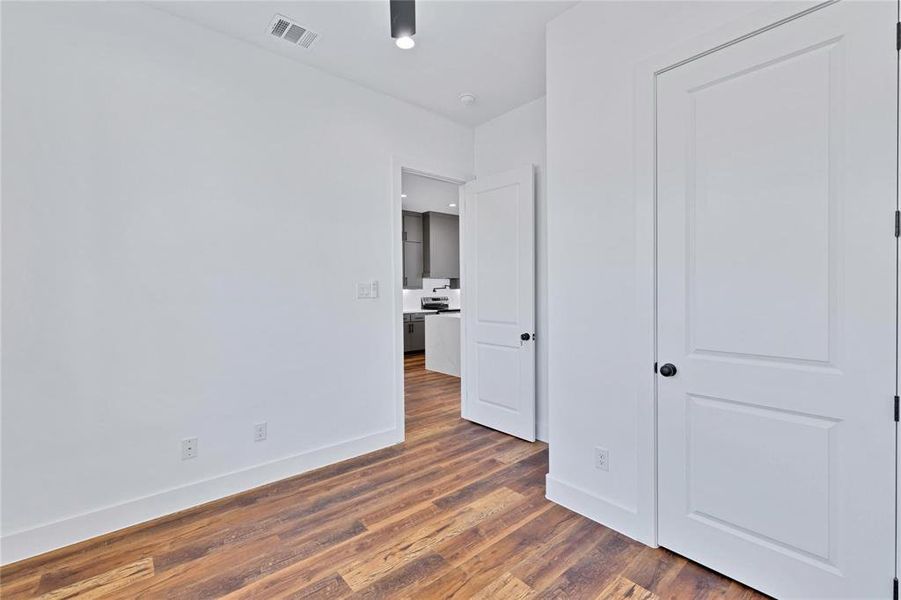 Unfurnished bedroom featuring baseboards and dark wood-style floors