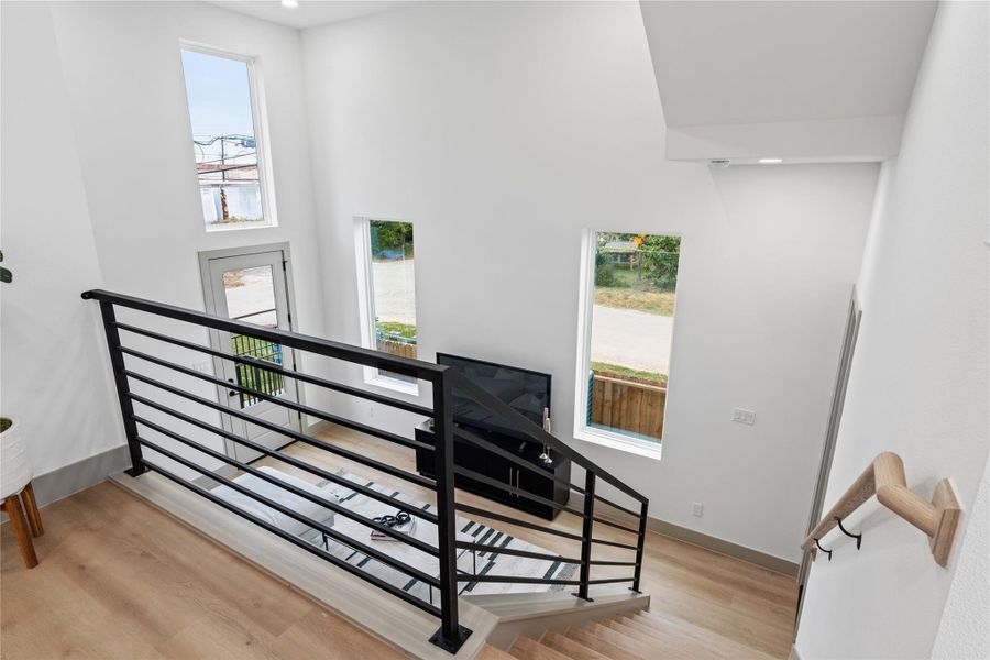Elevated dining with a view—this airy overlook connects seamlessly to the living room below, enhanced by 18-ft ceilings, oversized windows, and sleek modern railings.