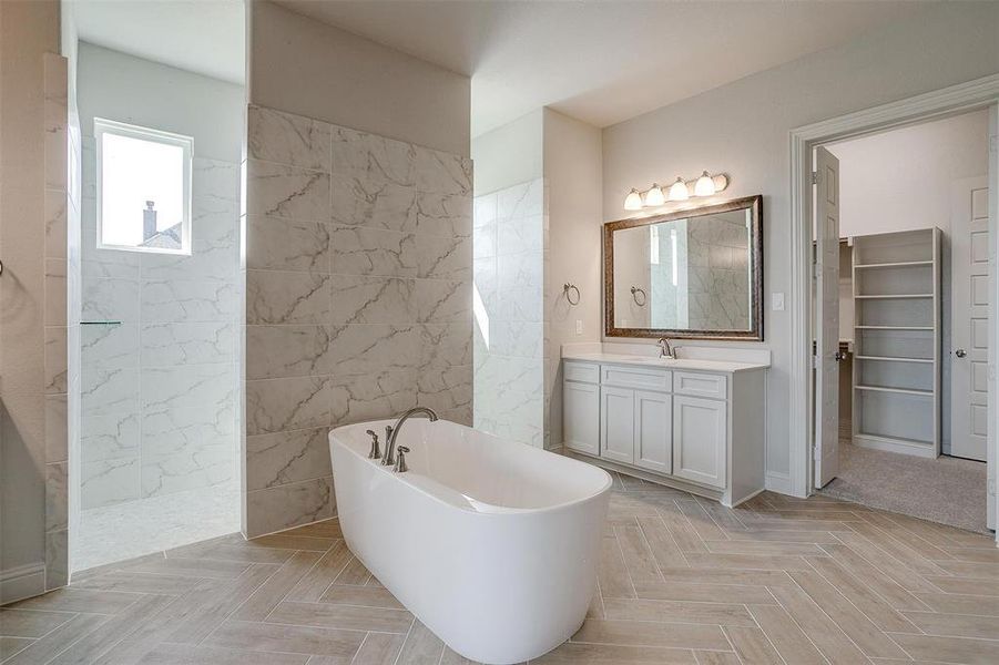 Bathroom featuring plus walk in shower, parquet floors, and vanity