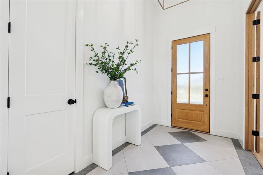Foyer features lovely light fixture and custom porcelain tile laid over crack prevention tile membrane. Solid oak French doors to office.