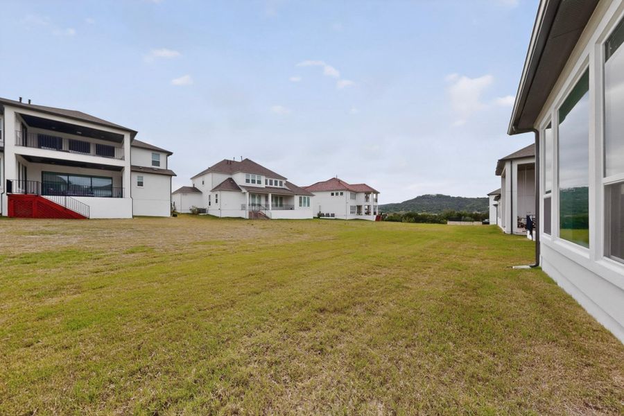 Expansive green space featuring distant hill scenery
