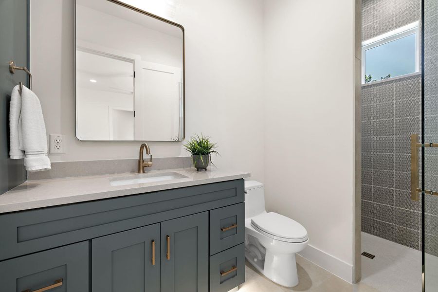 Full bath with baseboards, tiled shower, toilet, tile patterned floors, and vanity