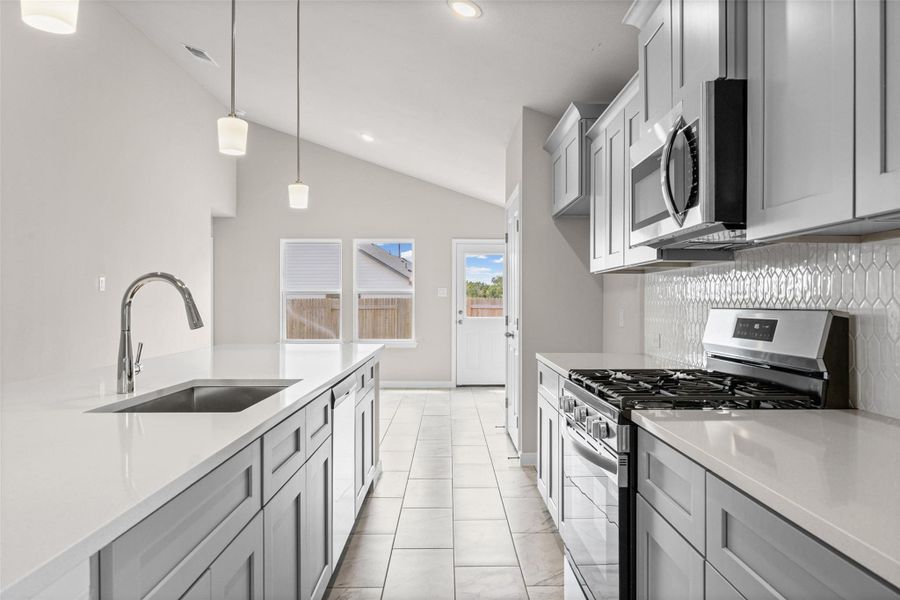 A vaulted ceiling enhances this contemporary kitchen equipped with stone countertops and tile flooring. A vaulted ceiling enhances this contemporary kitchen equipped with stone countertops and tile flooring.