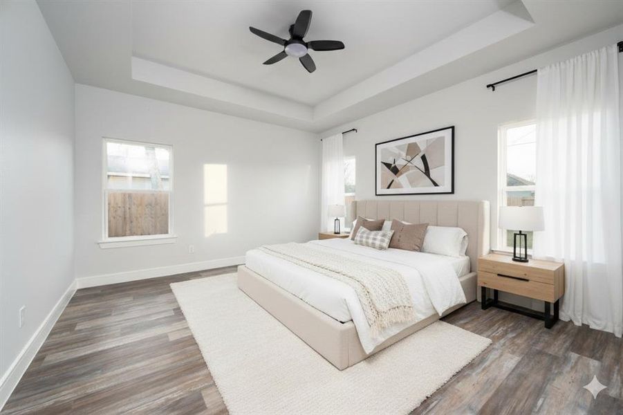 Virtually generated decoration. Bedroom with a raised ceiling, multiple windows, dark wood finished floors, and a ceiling fan