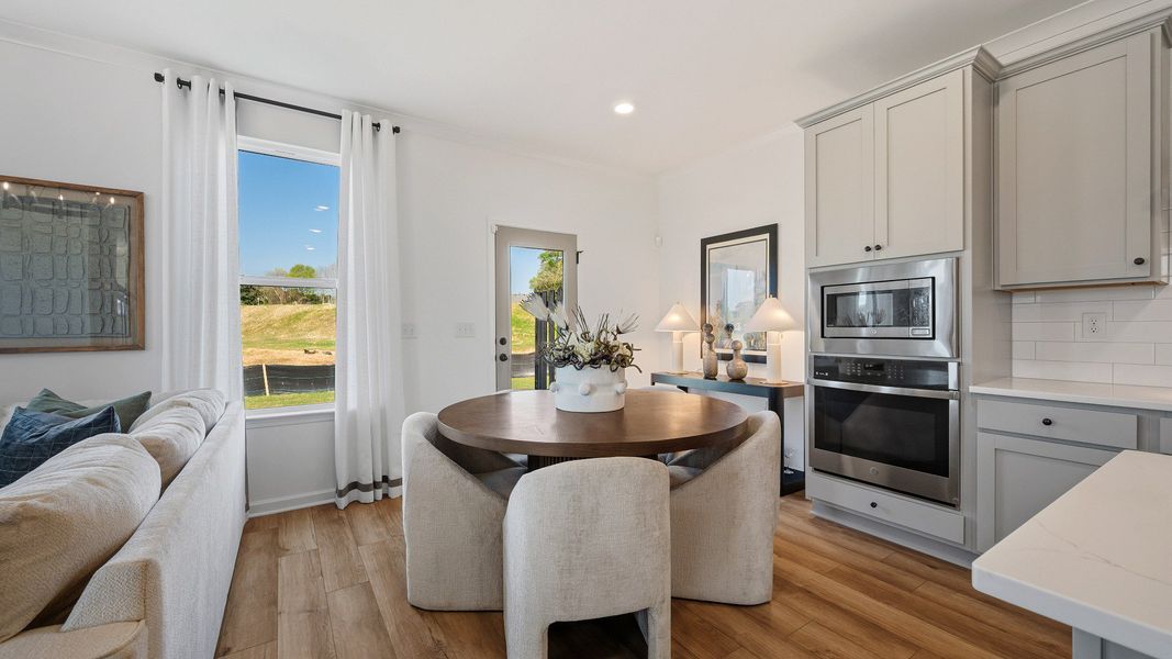 Open breakfast space with abundant natural light and seamless flow from kitchen in townhome in Loganville, GA.