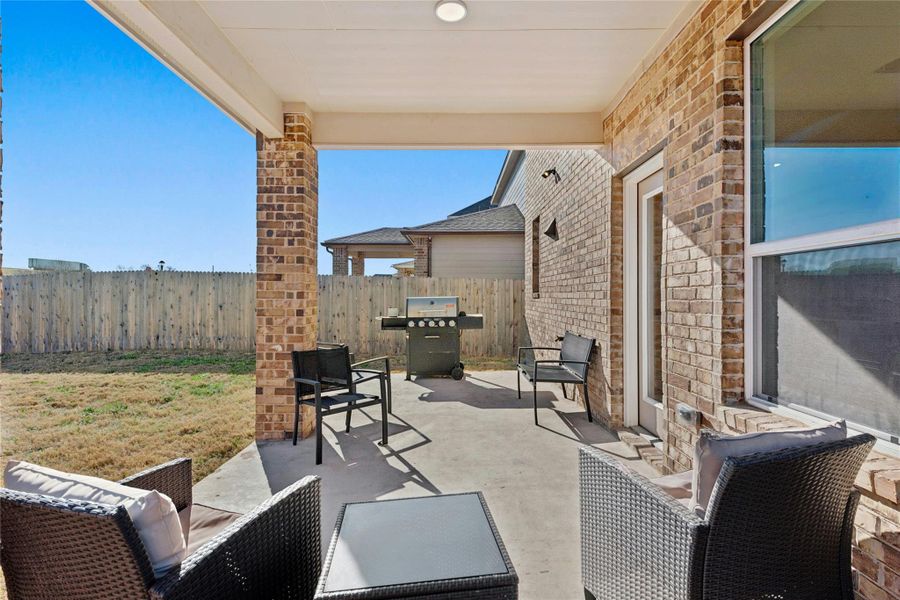 Fenced backyard featuring a grill, extended covered patio area ideal for gatherings and endless hours of entertainment