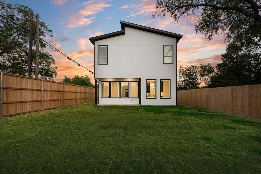 Back of property featuring a fenced backyard and stucco siding