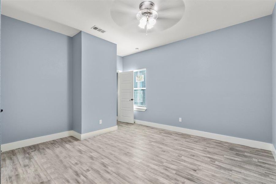 Empty room with light wood-type flooring and ceiling fan