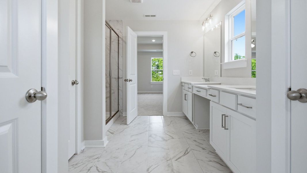 Bathroom with access to separate toilet, along with glass enclosed shower and dual vanity leading to primary suite Bathroom with access to separate toilet, along with glass enclosed shower and dual vanity leading to primary suite