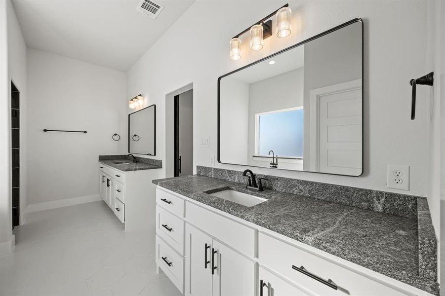 Full bath with two vanities and light tile patterned floors