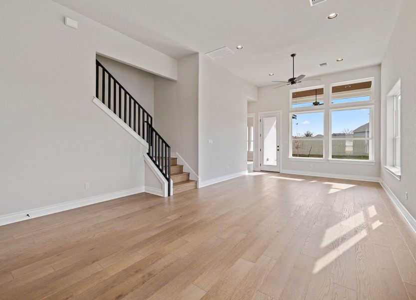 Unfurnished living room featuring recessed lighting, stairs, ceiling fan, light wood finished floors, and visible vents Unfurnished living room featuring recessed lighting, stairs, ceiling fan, light wood finished floors, and visible vents