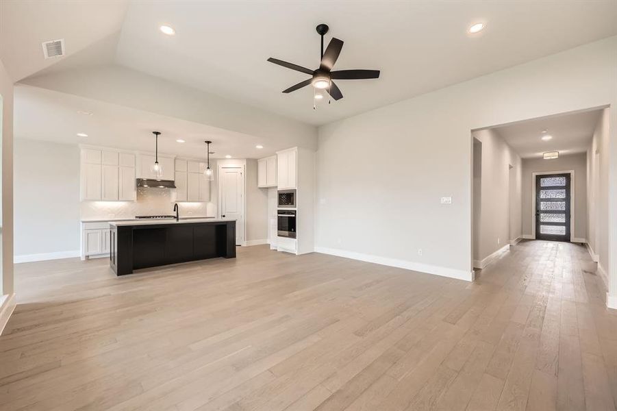 Kitchen featuring visible vents, stainless steel appliances, a ceiling fan, and open floor plan Kitchen featuring visible vents, stainless steel appliances, a ceiling fan, and open floor plan