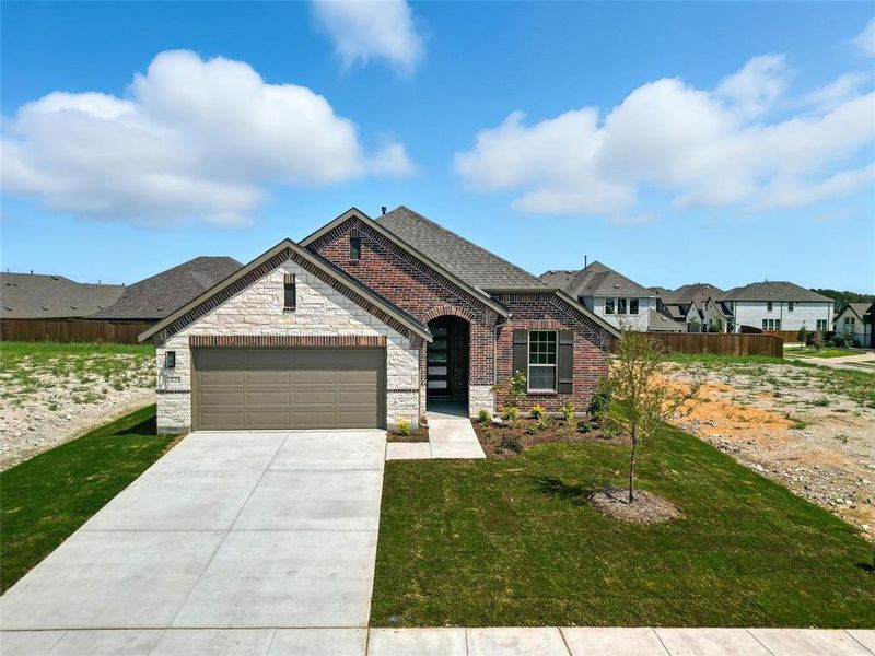 French provincial home featuring an attached garage, driveway, brick siding, stone siding, and a residential view French provincial home featuring an attached garage, driveway, brick siding, stone siding, and a residential view