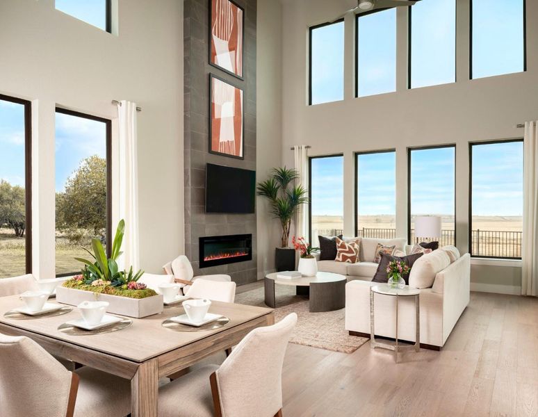 Living area featuring light wood-style floors, a fireplace, and a high ceiling