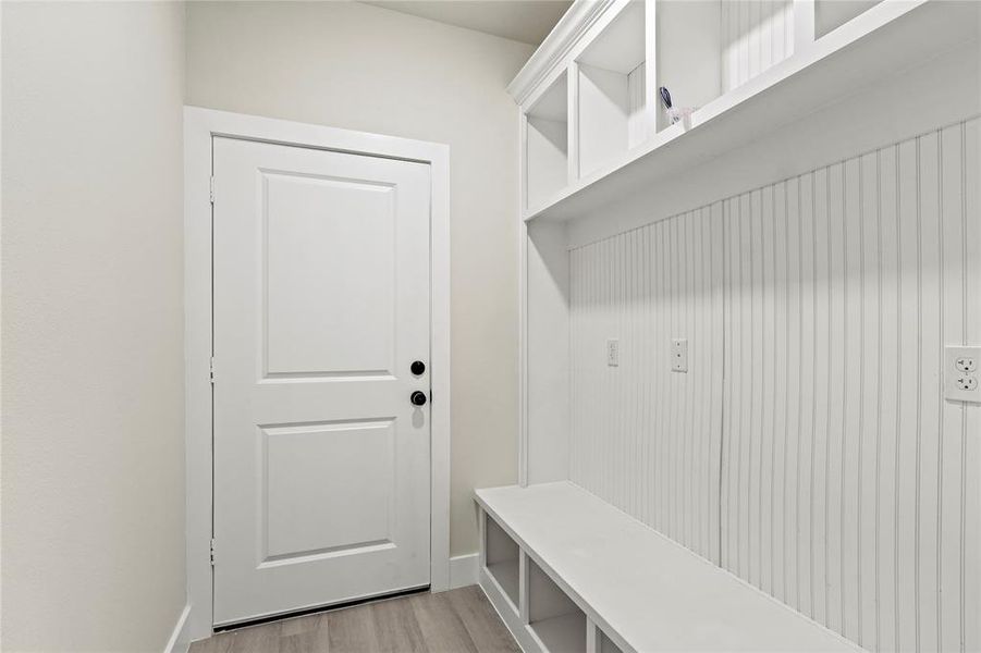 Mudroom with light wood-style floors and baseboards