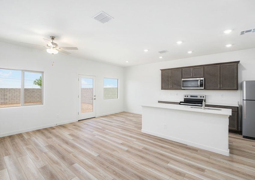 The living area is filled with natural light from large windows creating a warm environment.