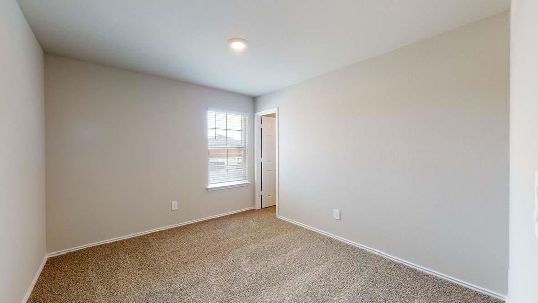 Neutral-toned room featuring light beige walls and complementary textured carpeting