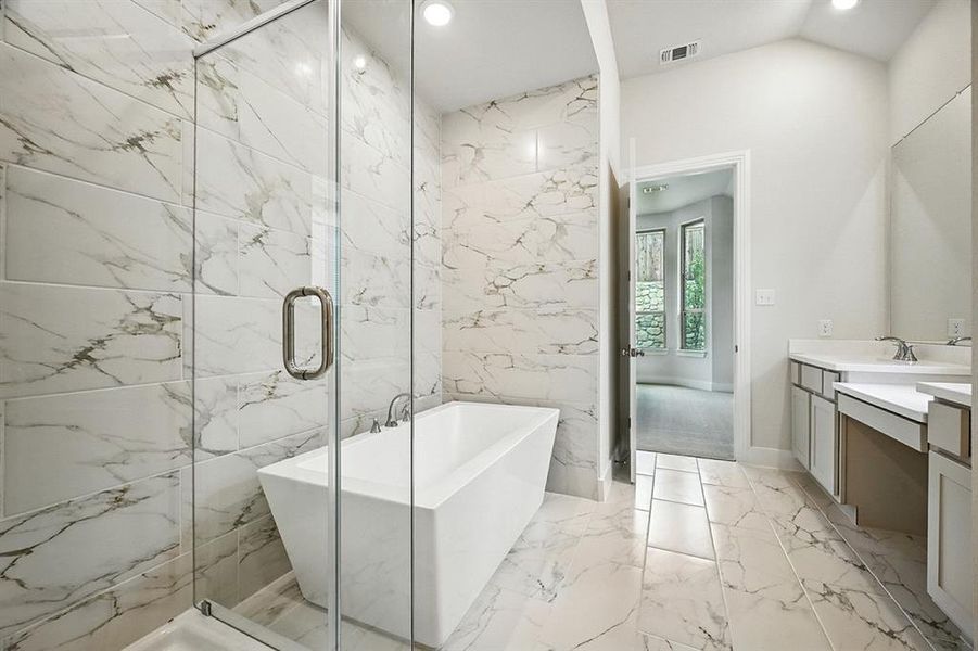 Bathroom featuring vanity, light marble finish floors, a freestanding bath, a marble finish shower, and tile walls Bathroom featuring vanity, light marble finish floors, a freestanding bath, a marble finish shower, and tile walls