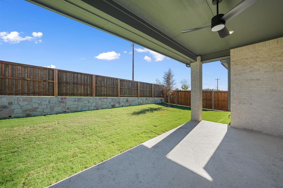 Fenced backyard featuring a ceiling fan and a patio area Fenced backyard featuring a ceiling fan and a patio area