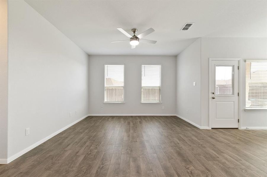 Unfurnished living room with dark wood-style flooring and ceiling fan