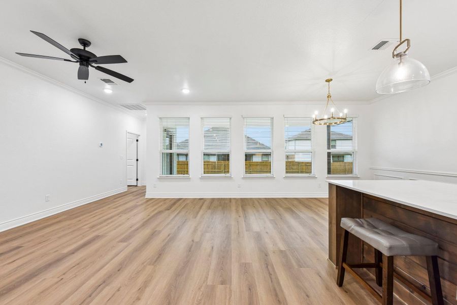 A spacious common area with abundant natural light from multiple windows, illuminated by a modern chandelier and recessed lighting. A spacious common area with abundant natural light from multiple windows, illuminated by a modern chandelier and recessed lighting.
