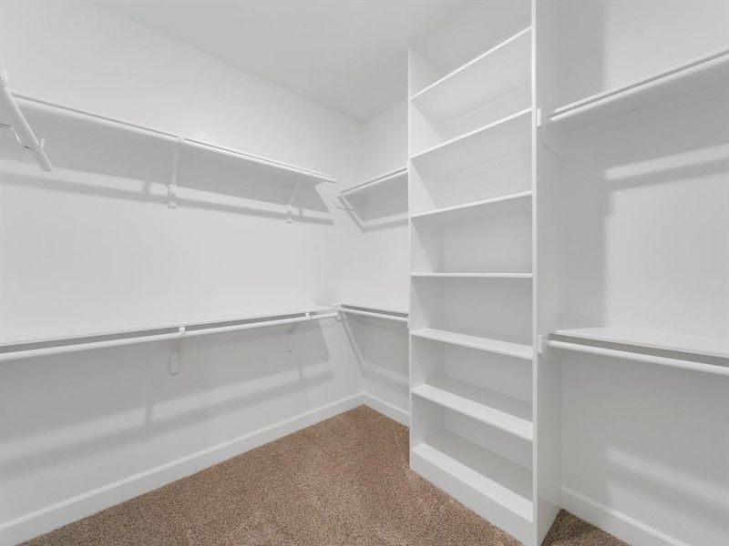 One of two large Primary Bedroom Closets with built-in shelving! (Sample photos of a completed Warwick floor plan. The image may feature alternative selections and/or upgrades.)