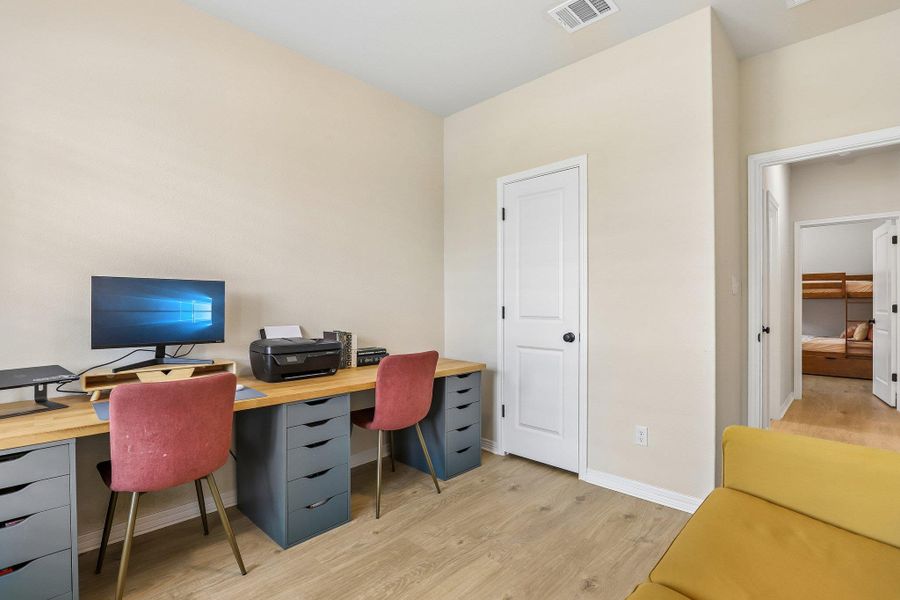 A versatile room offering a dedicated workspace and easy access to an adjoining sleeping area.