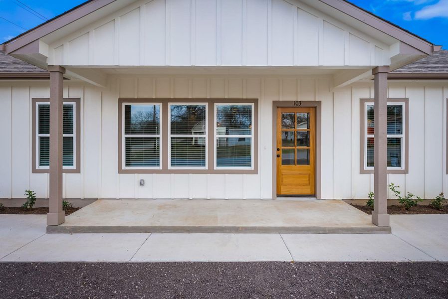 Entrance to property with a shingled roof and a porch