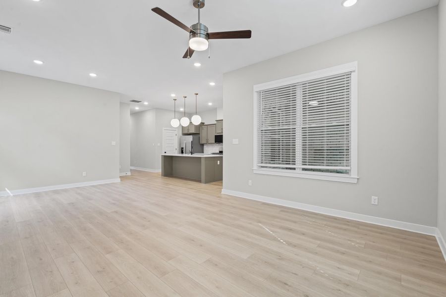 Unfurnished living room featuring light wood-style flooring, ceiling fan, and recessed lighting