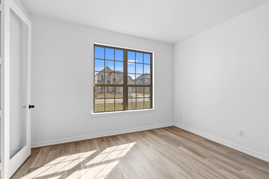 Private study at the front of the home featuring gorgeous flooring and large windows—perfect for work or creativity.