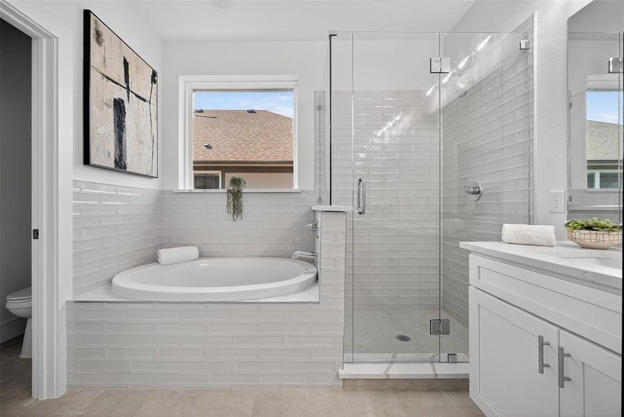 Bathroom featuring a bath, vanity, and a stall shower