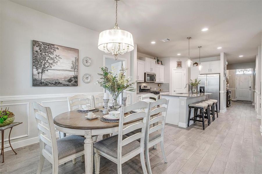 Dining area with an inviting chandelier, light wood-type flooring, visible vents, and recessed lighting